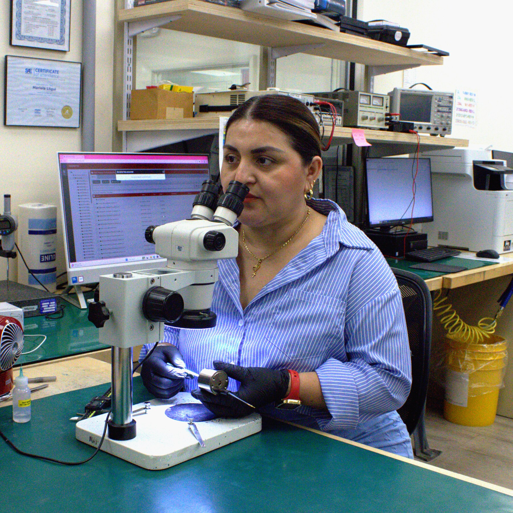 Sag Harbor Industries employee inspecting a component under a microscope
